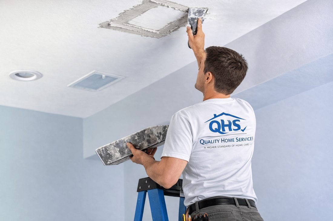 Quality Home Services technician patching and repairing a drywall ceiling