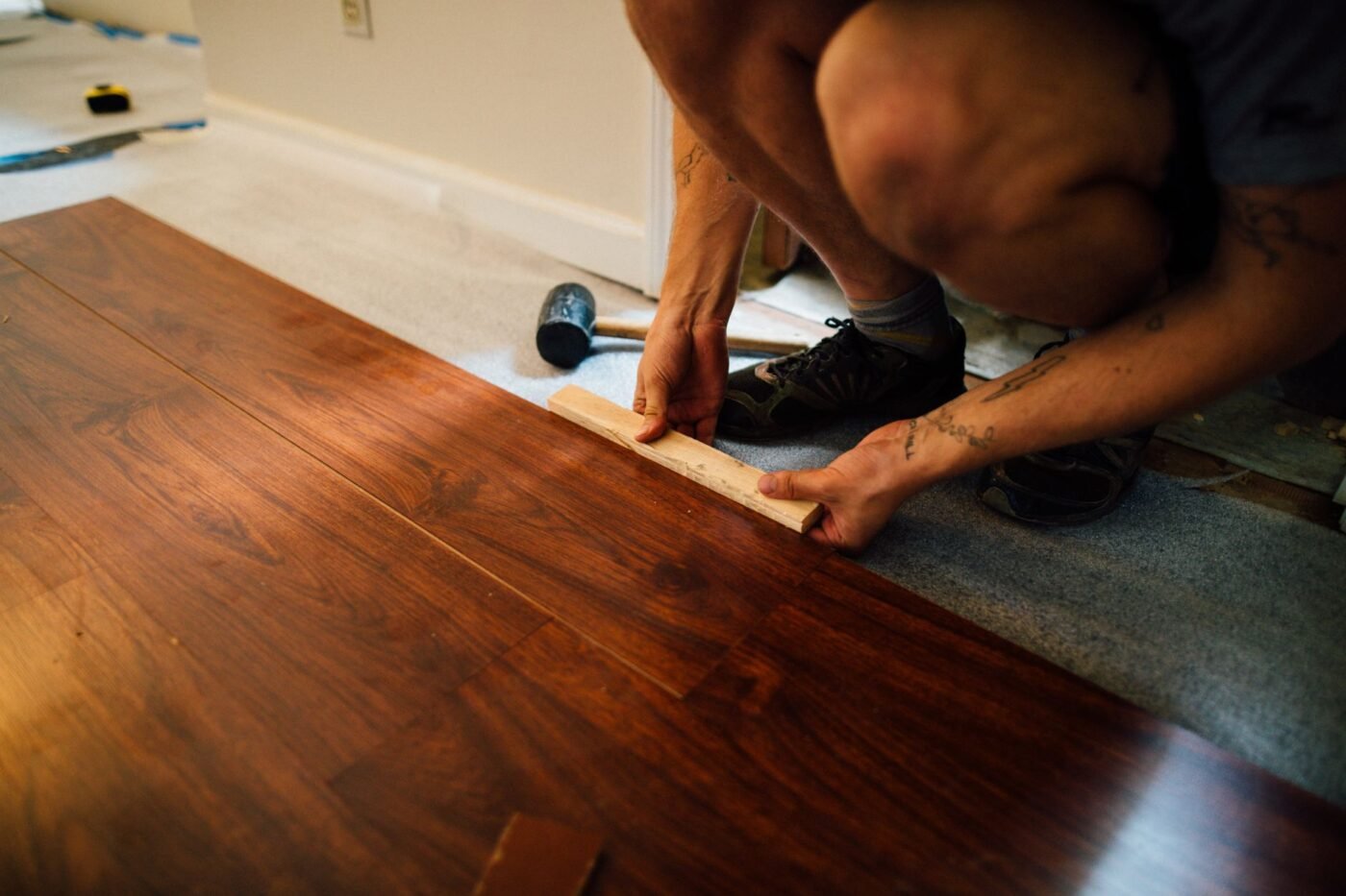 Laying wood-look flooring planks during a flooring repair in Tampa, FL